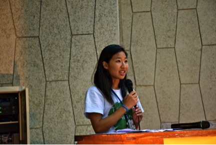 The author, Sunny Yang, holding a microphone and being the MC for the closing ceremony of the summer pre-service training.
